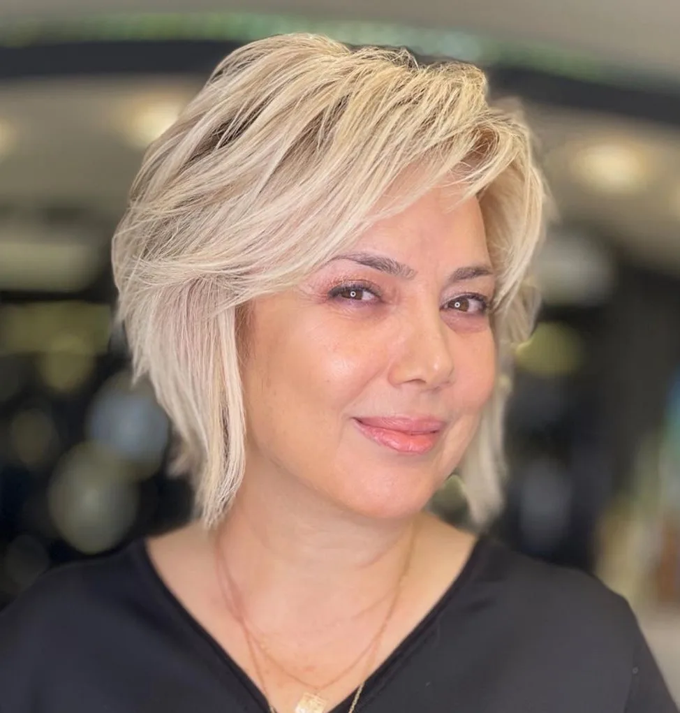 Pixie bob blond aux longues couches plumeuses et racines ombrées