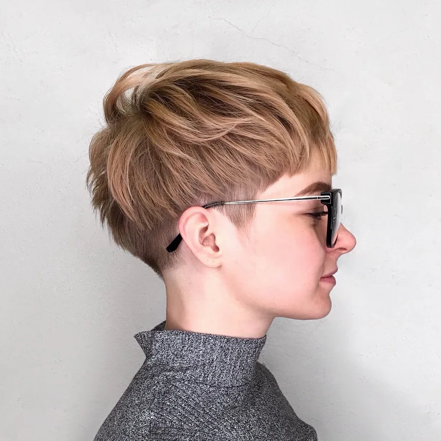 Pixie choppy avec undercut sur les côtés et volume sur le dessus