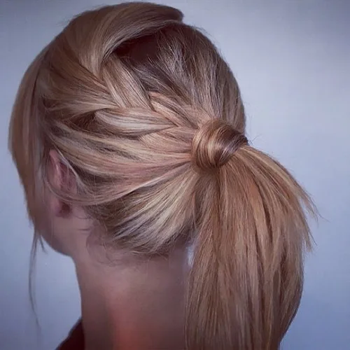 Queue de cheval avec tresse latérale et base enroulée sur cheveux dégradés