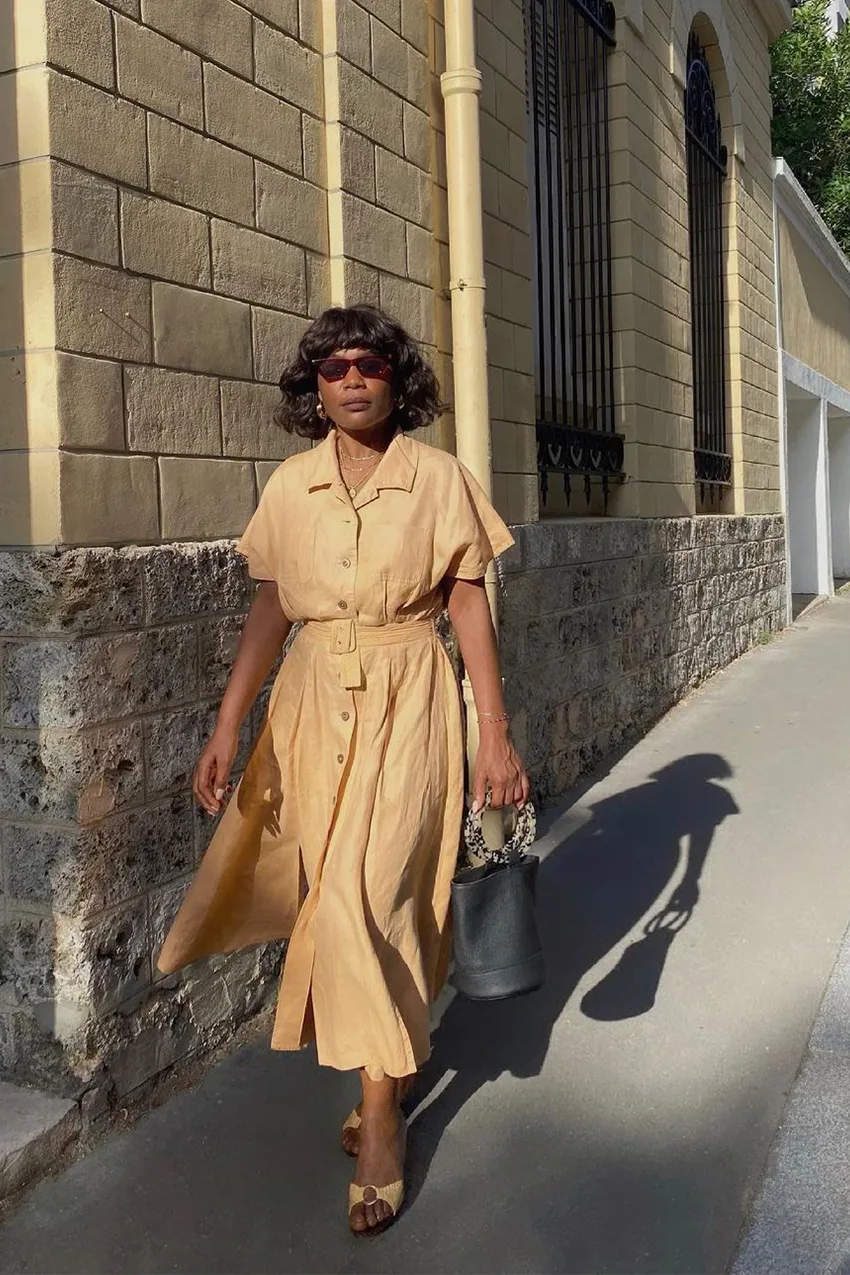 Robe chemise camel portée avec des lunettes et des sandales
