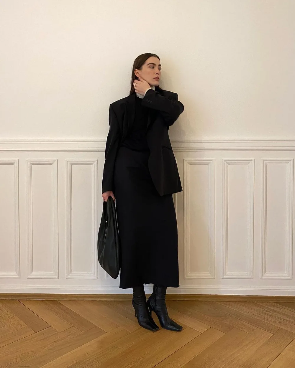 Robe midi noire portée sur un col roulé blanc avec des bottines à talon kitten