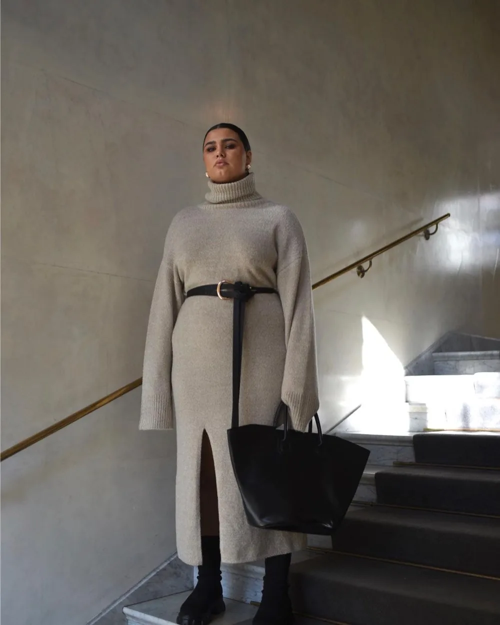 Robe pull maxi beige ceinturée portée avec des bottes à semelle chunky