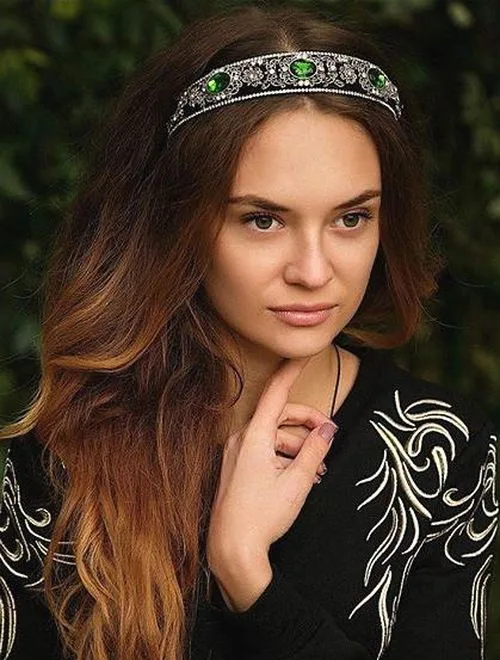 Serre-tête vert émeraude orné posé sur cheveux longs ondulés châtains