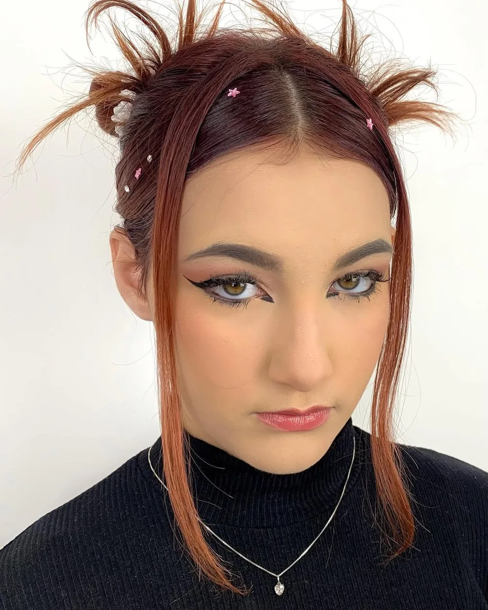 Space buns années 2000 version grunge avec pointes qui dépassent et mèches libres