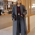 Tenue de bureau automne manteau en laine gris avec cardigan bordeaux, chemise blanche et pantalon large noir