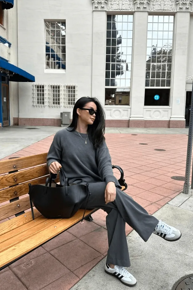 Tenue de bureau automne sweat anthracite avec pantalon noir et baskets blanches à bande