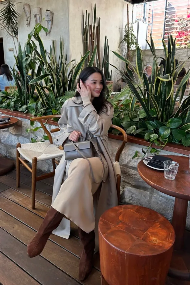 Tenue de bureau automne trench beige avec pantalon crème, pull taupe et bottes marron
