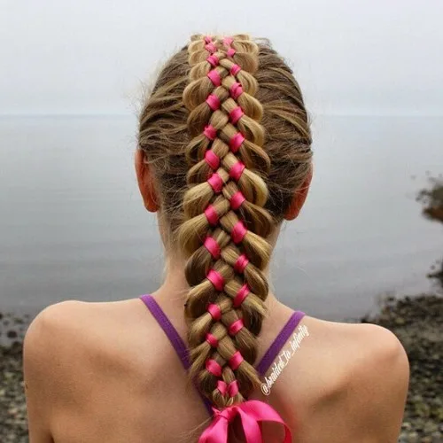 Tresse à quatre brins tissée avec un ruban rose sur cheveux longs et lisses