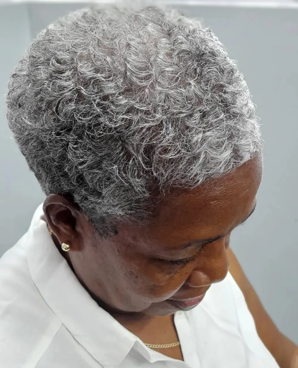 TWA très court gris naturel mettant la boucle à l'honneur
