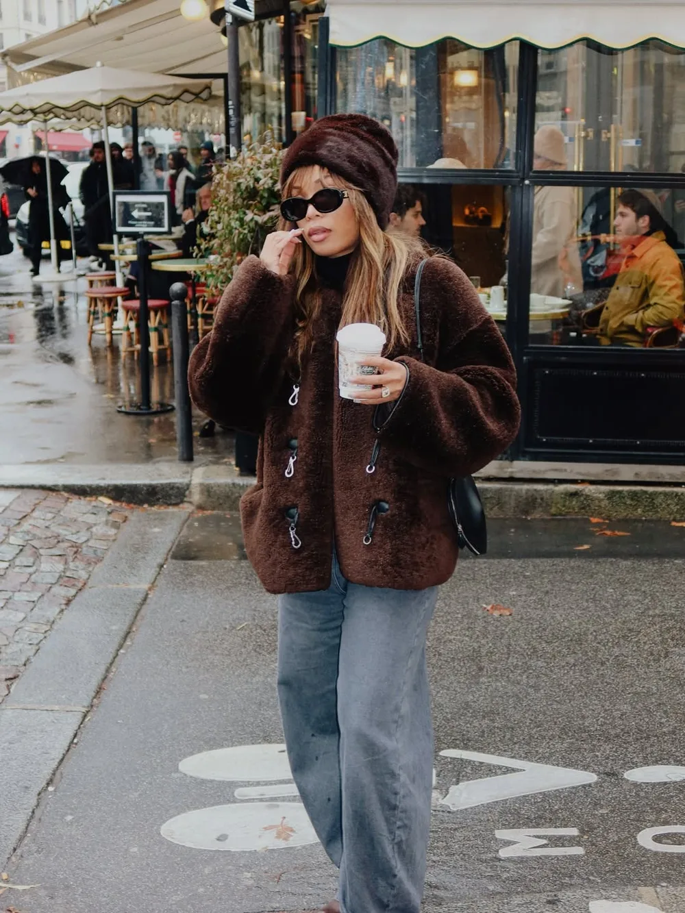 Veste en fausse fourrure marron portée avec un bonnet assorti