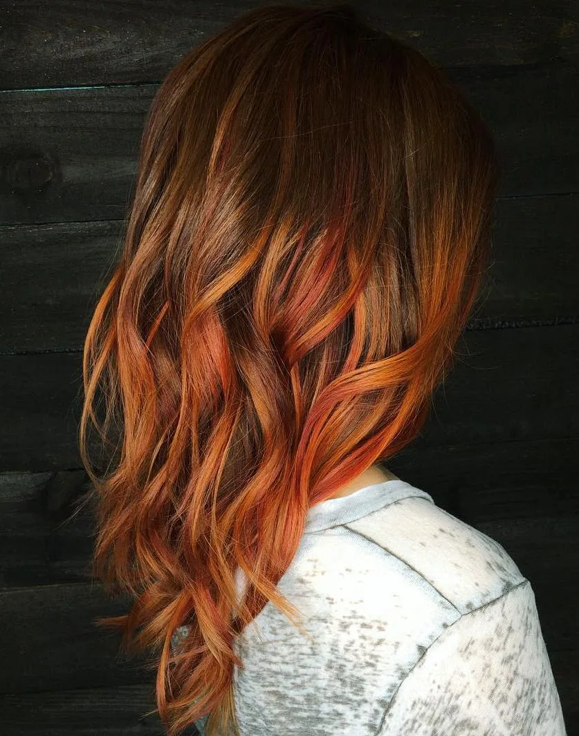 Balayage cuivré chaud sur base brune, longueurs ondulées