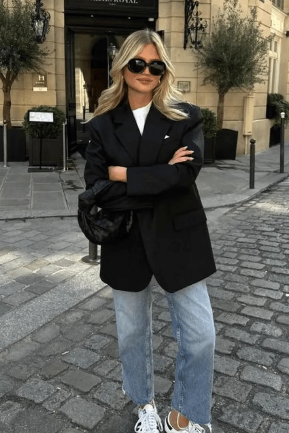 Blazer noir oversize porté sur un tee-shirt blanc avec un jean et des baskets