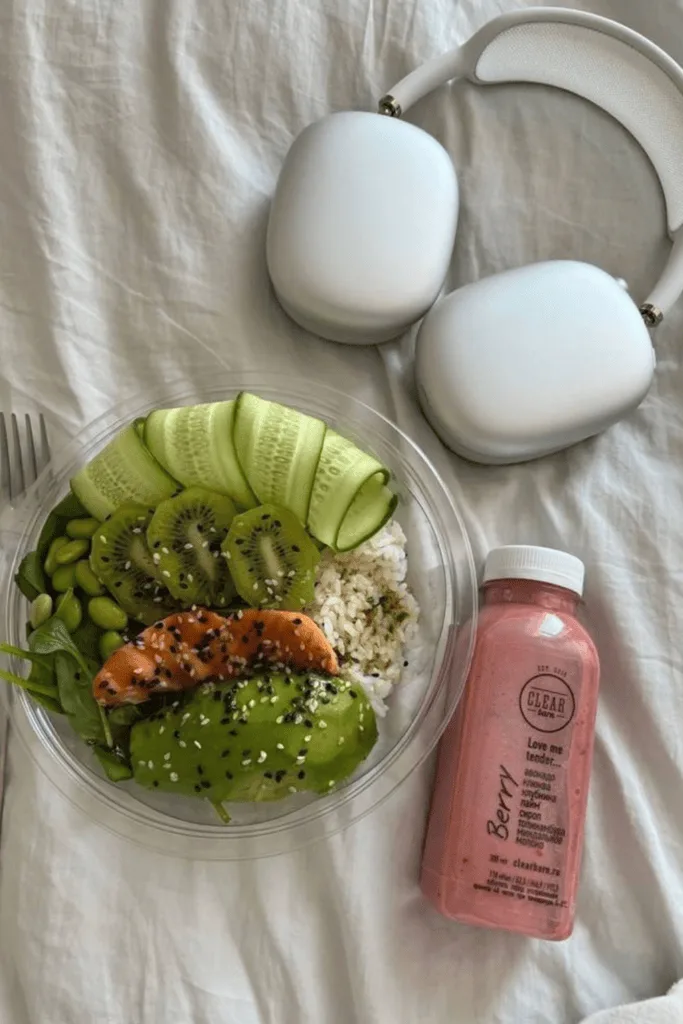 Bol repas avec avocat et saumon, à côté d'une boisson aux fruits rouges