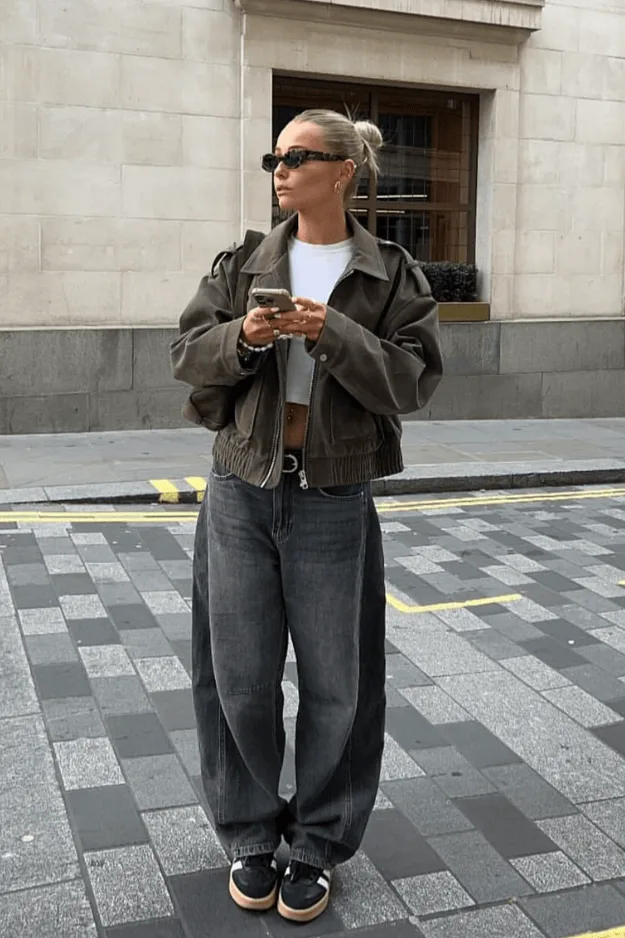 Bomber en daim porté avec un jean baggy gris et des baskets noires