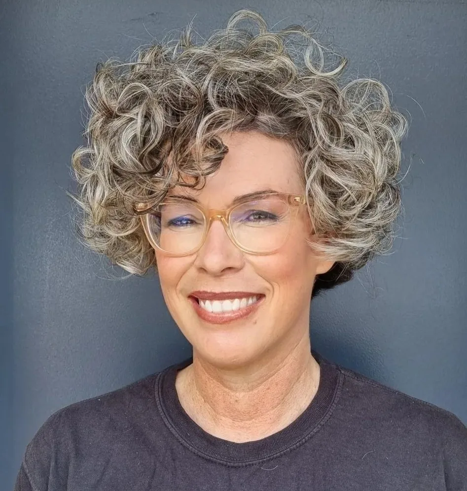 Boucles rondes grises volumineuses sur femme de 60 ans avec lunettes