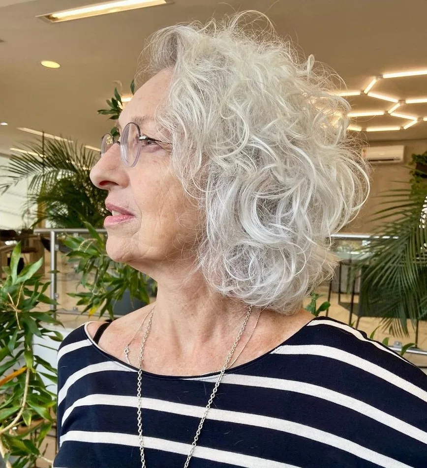 Carré bouclé gris à hauteur de nuque, femme à lunettes