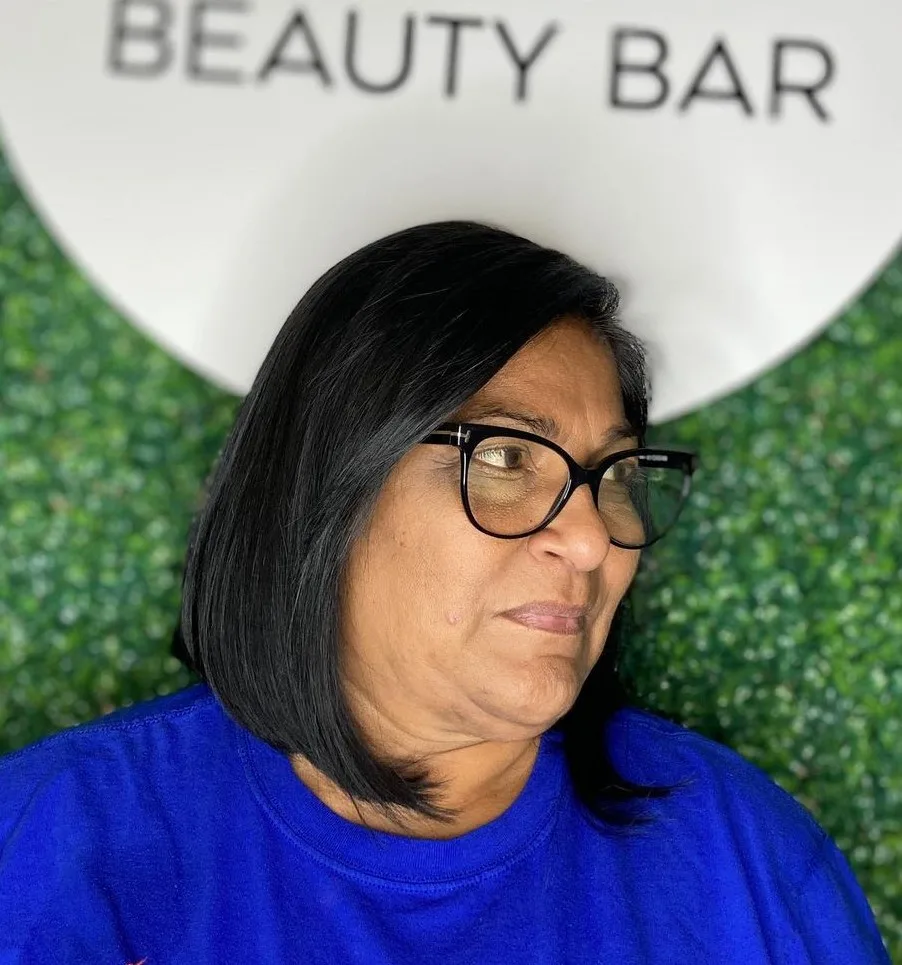 Carré brun lisse à raie de côté sur femme de 60 ans à lunettes