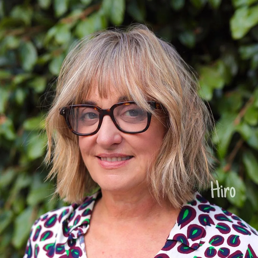 Carré choppy à frange effilée, femme de 60 ans à lunettes colorées