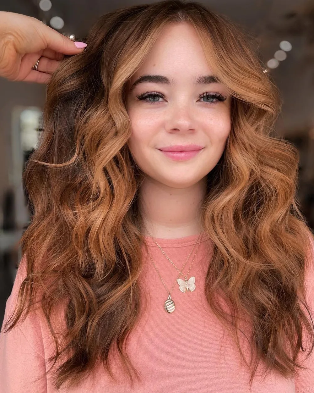 Cheveux avec money piece fraise cuivré encadrant le visage, de face avec frange