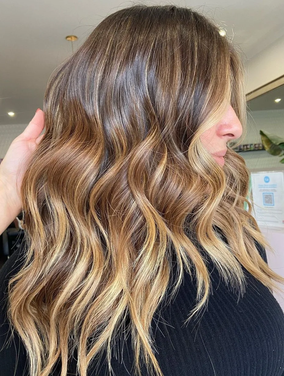 Cheveux bruns avec balayage bronde dimensionnel multi-tons, ondulations, de profil