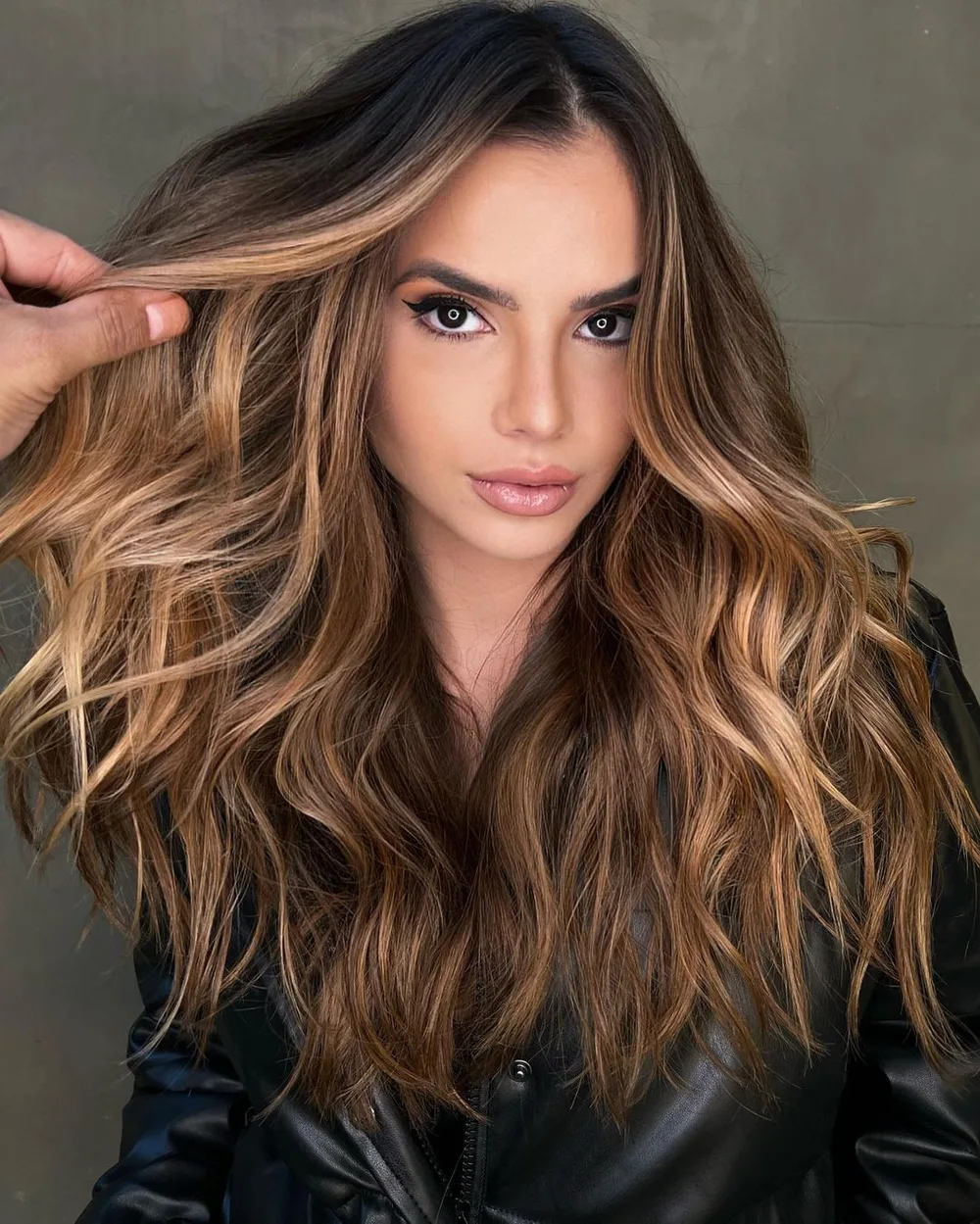 Cheveux bruns avec balayage caramel doré, longues ondulations souples, de face