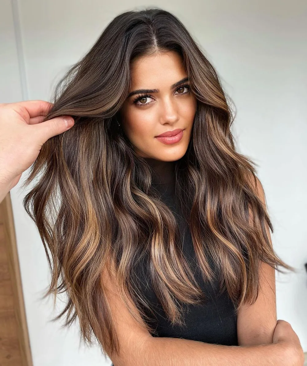 Cheveux bruns avec balayage caramel encadrant le visage façon contouring, de face