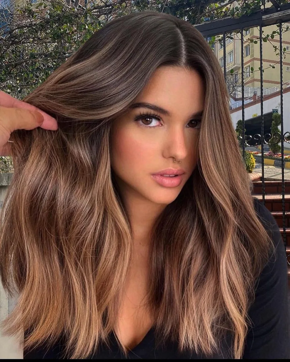 Cheveux bruns très longs avec money piece caramel et balayage, de face