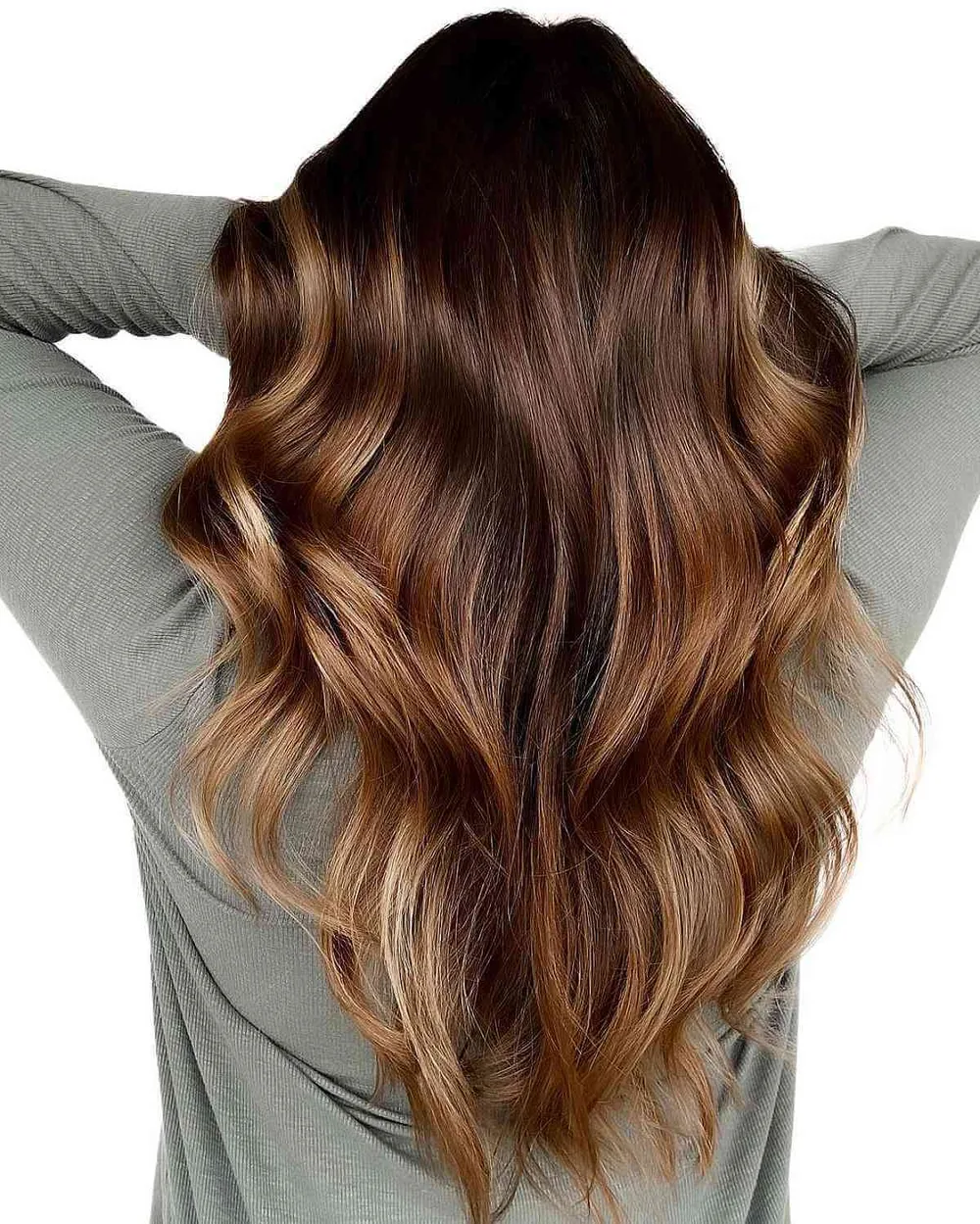 Cheveux chocolat doux fondus de reflets miel, longueurs ondulées de dos