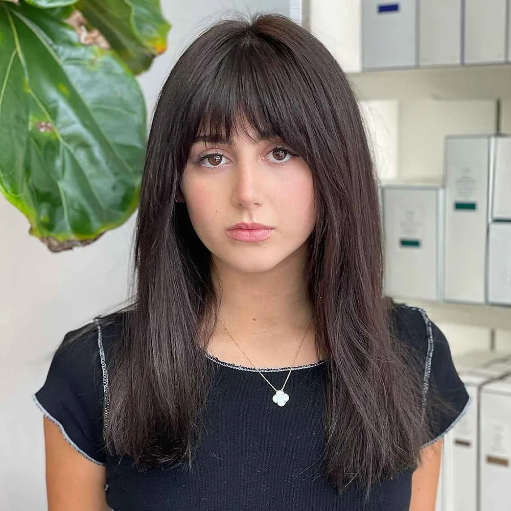 Cheveux chocolat foncé lisses avec frange droite, coupe mi-longue de face