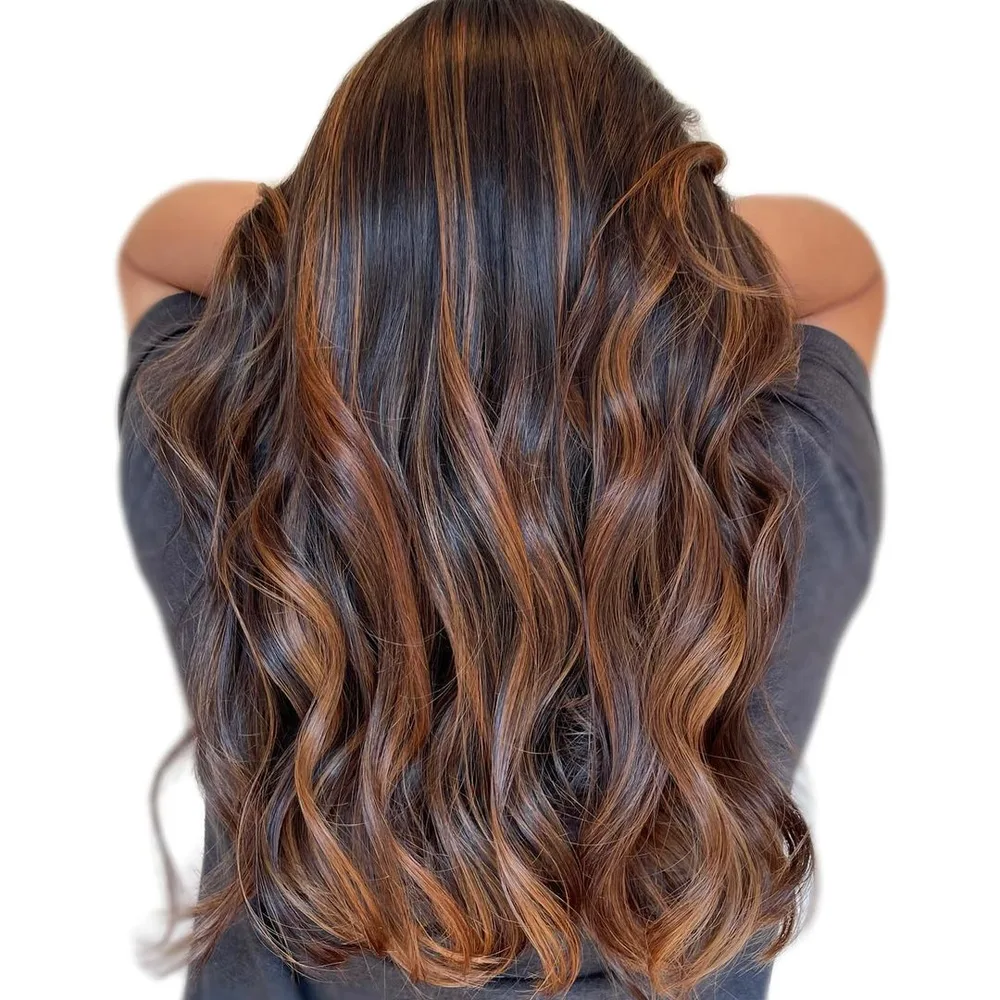 Cheveux en balayage fauve cuivré tirant sur le brun doré, longs de dos
