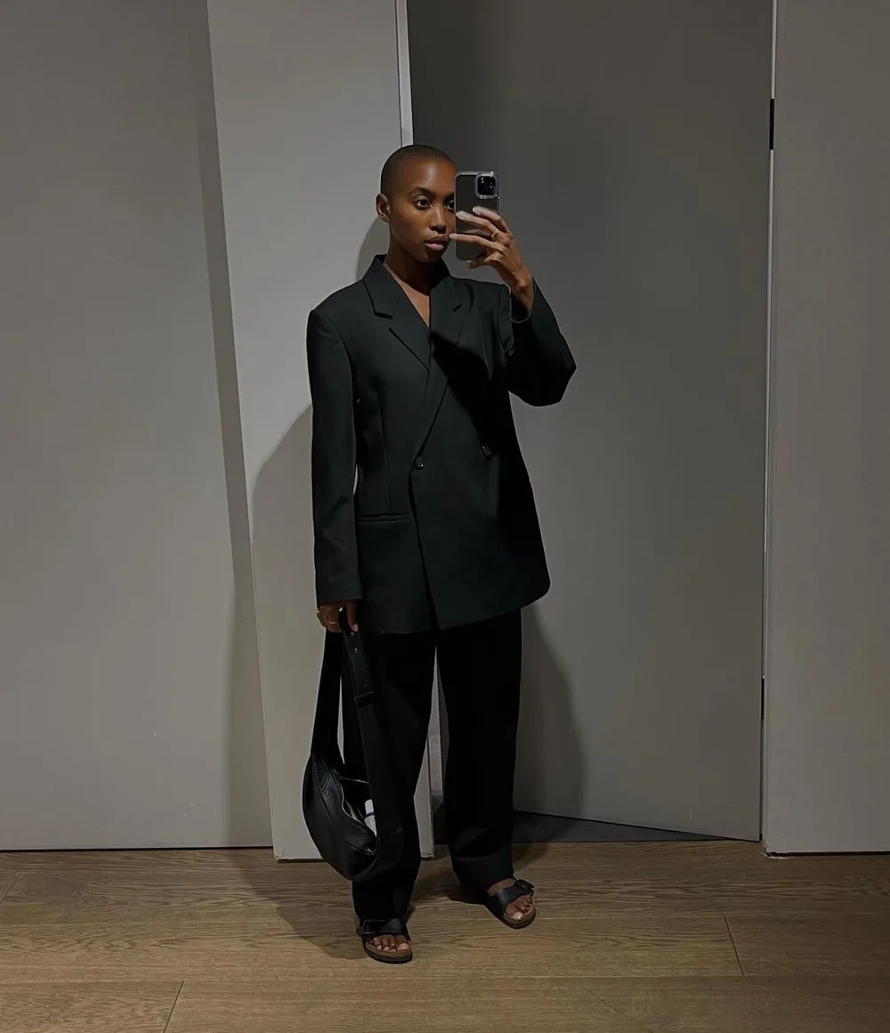 Costume noir ample avec blazer long, pantalon large et sandales noires