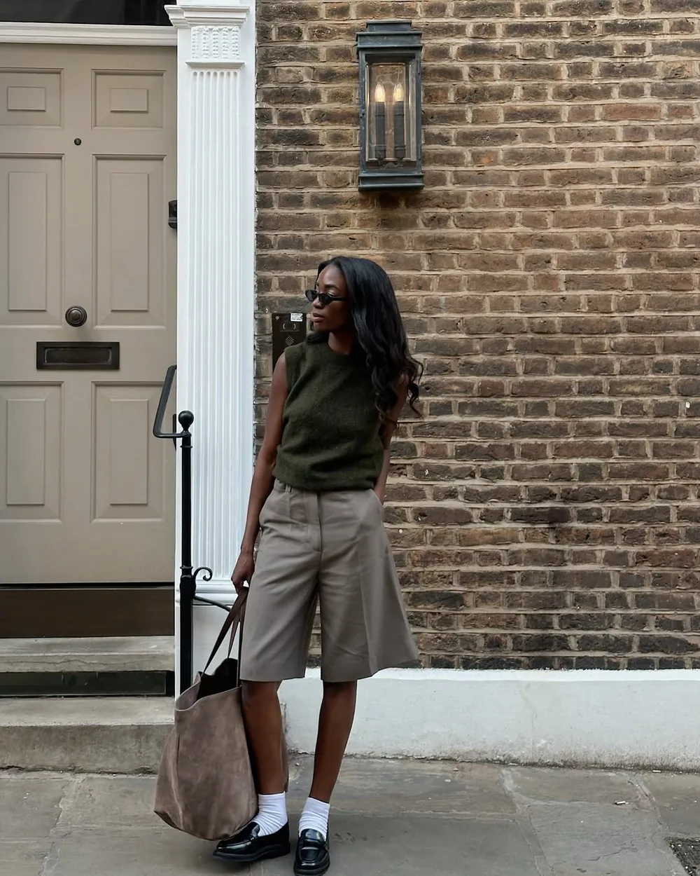 Débardeur kaki et bermuda gris portés avec des socquettes et des mocassins noirs