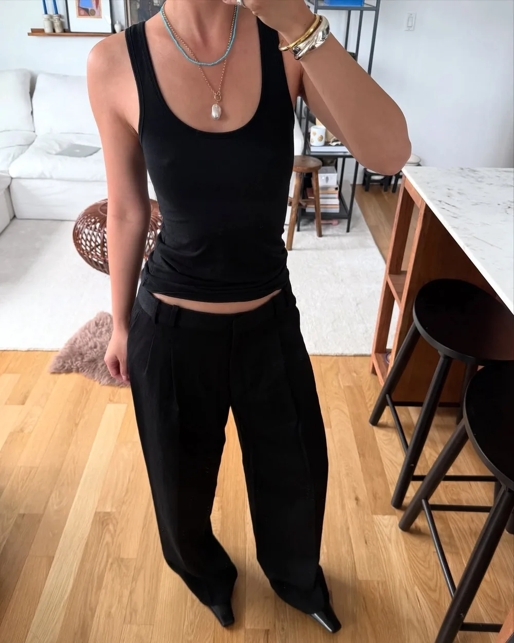 Débardeur noir ajusté avec pantalon noir souple et colliers colorés