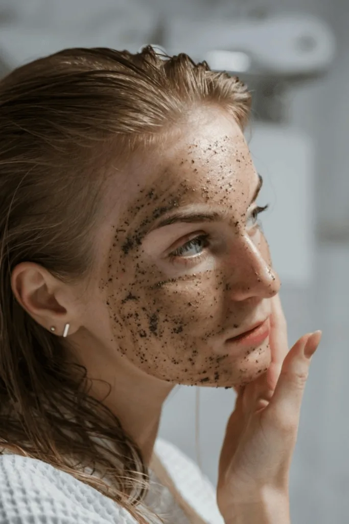 Femme appliquant un gommage exfoliant sur une moitié du visage