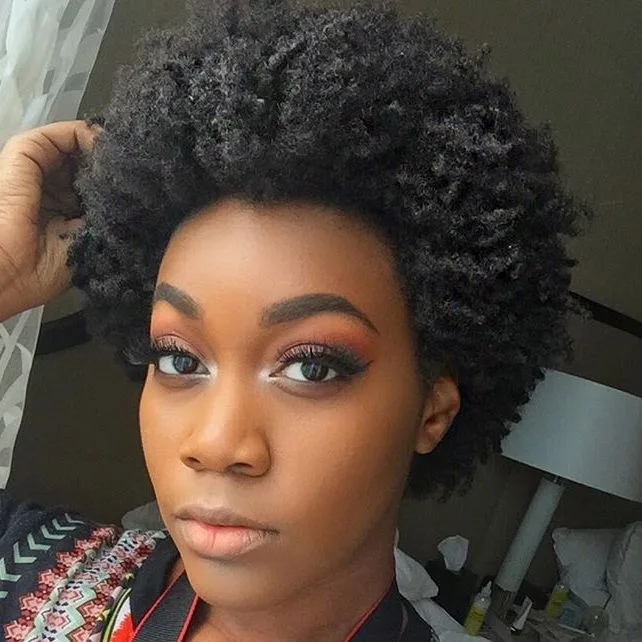 Femme aux cheveux crépus avec un afro puff haut volumineux sur le crâne, de face