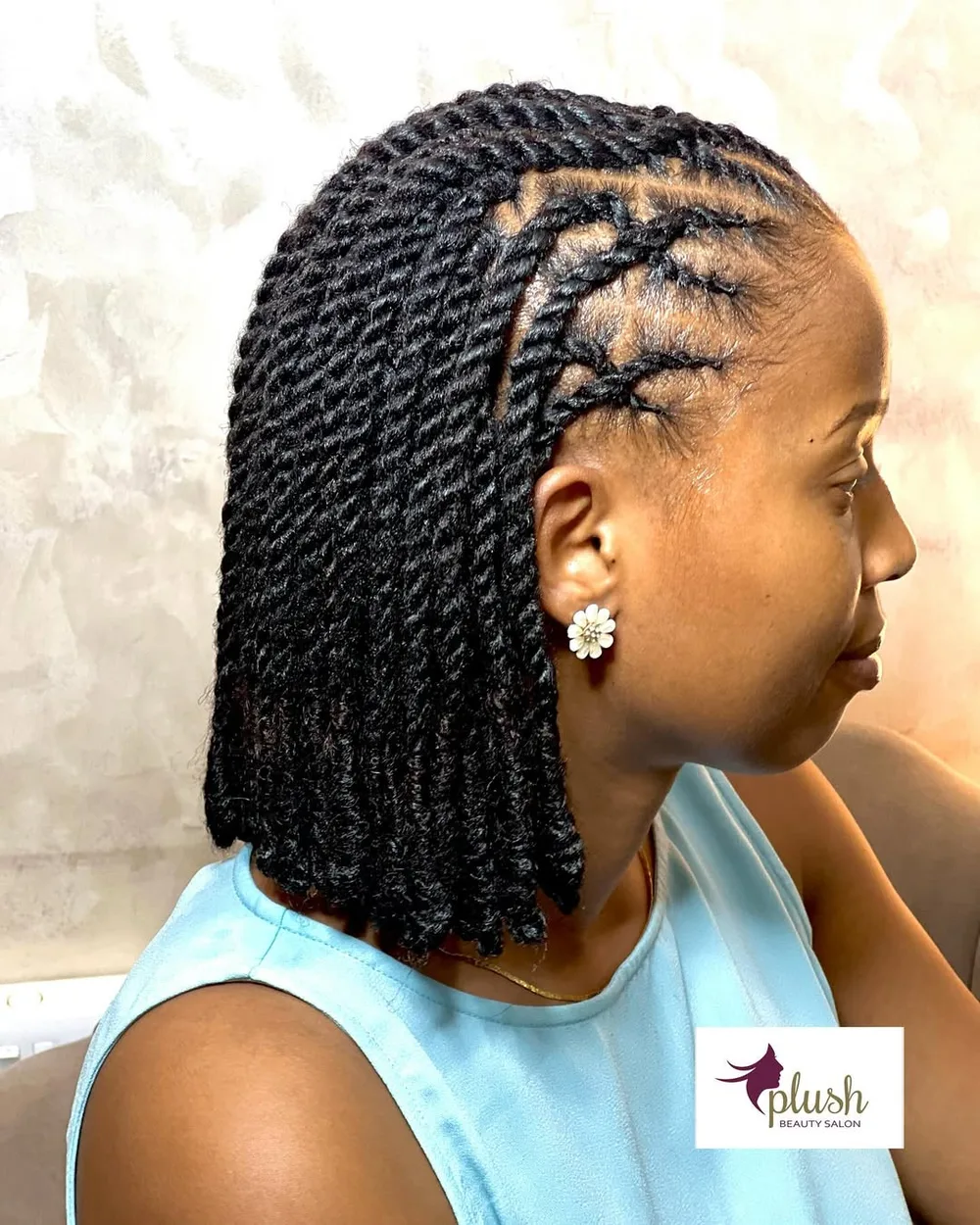 Femme aux cheveux crépus coiffée en cornrows collées et graphiques, de profil