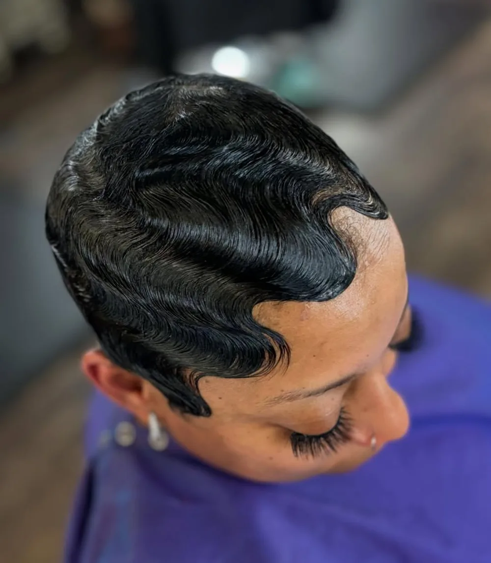 Femme aux cheveux crépus coiffée en finger waves plaquées et brillantes, de profil