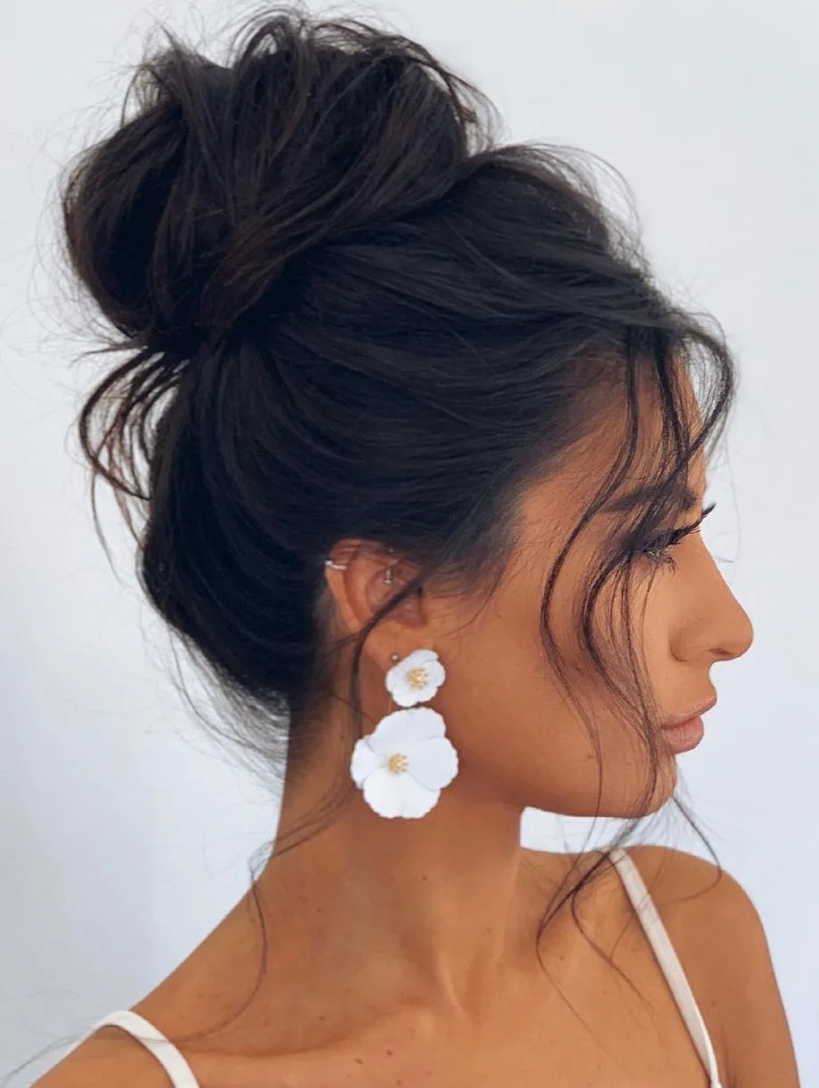 Femme aux cheveux lisses coiffée en chignon haut décontracté, de dos