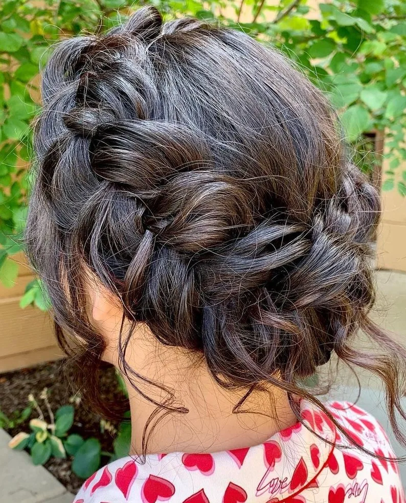 Femme aux cheveux lisses coiffée en couronne tressée autour de la tête, de face