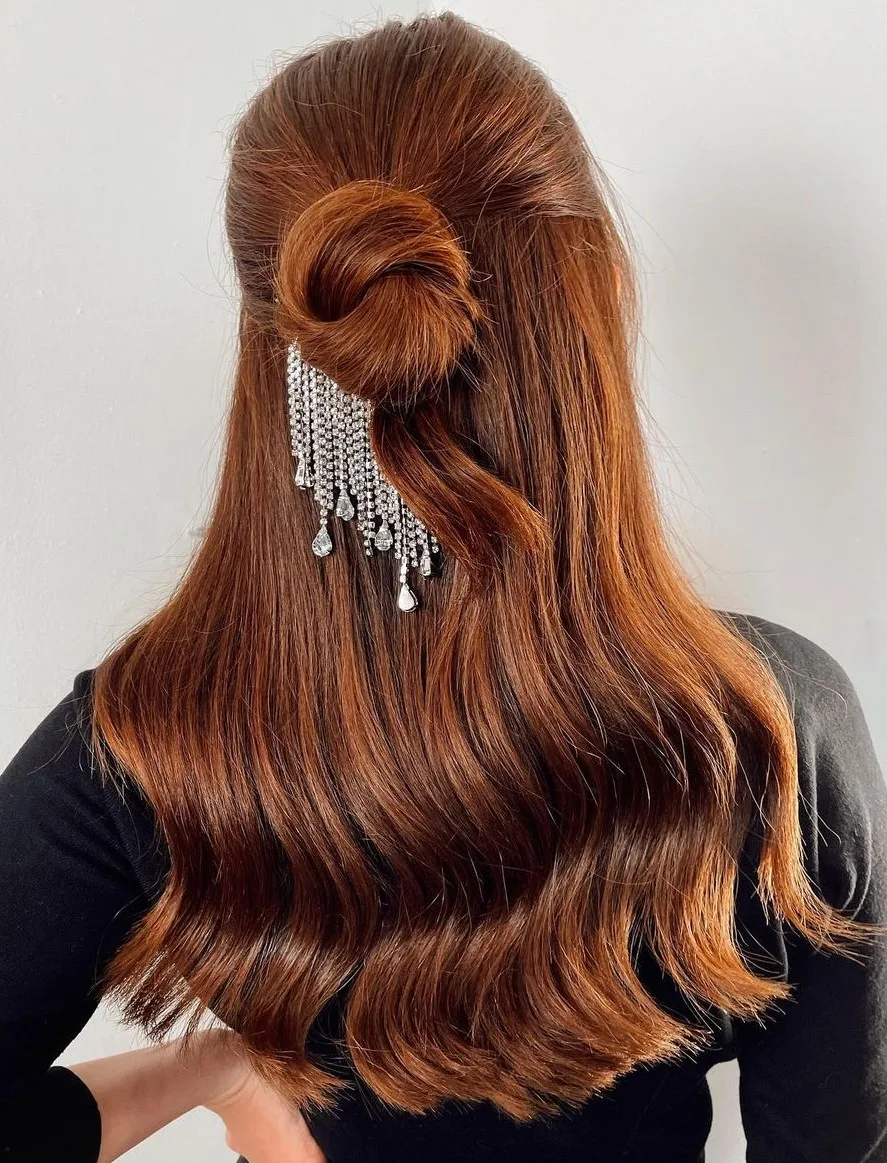 Femme aux cheveux lisses coiffée en demi-attaché maintenu par une barrette, de profil