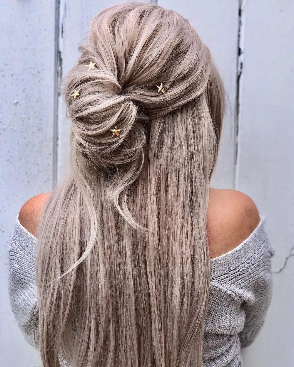 Femme aux cheveux lisses coiffée en demi-chignon torsadé, longueurs lâchées, de dos