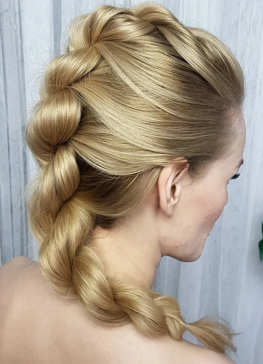 Femme aux cheveux lisses coiffée en tresse hollandaise volumineuse, de profil