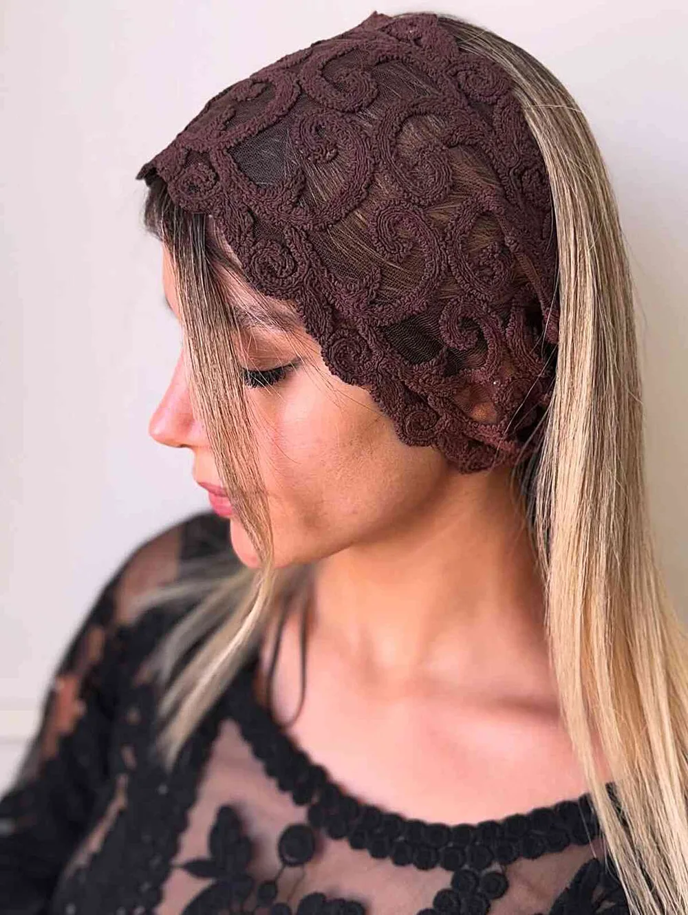 Femme avec un bandeau en dentelle sur cheveux bouclés bruns, de face