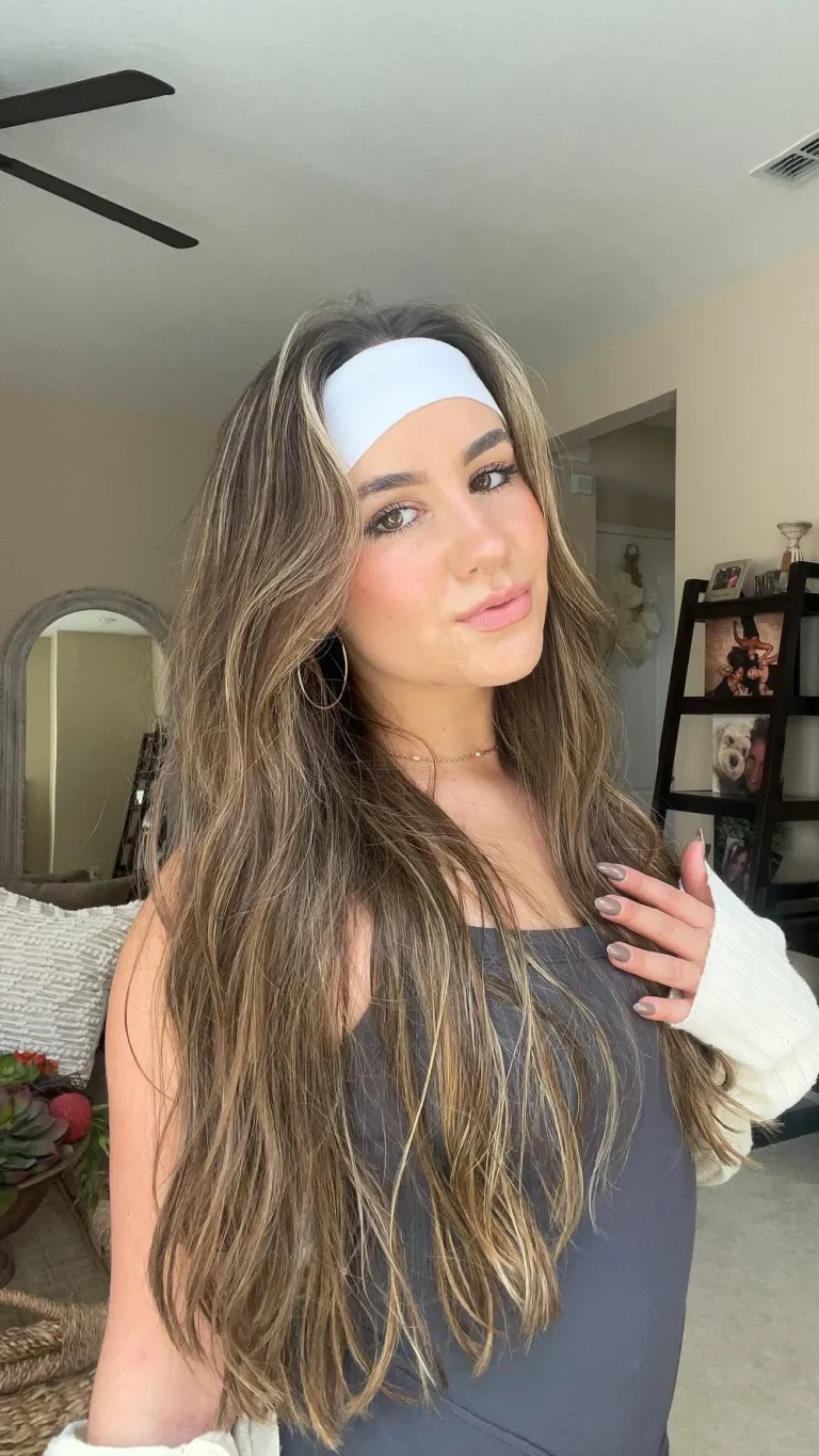 Femme avec un bandeau large satiné et de longs cheveux ondulés, de face