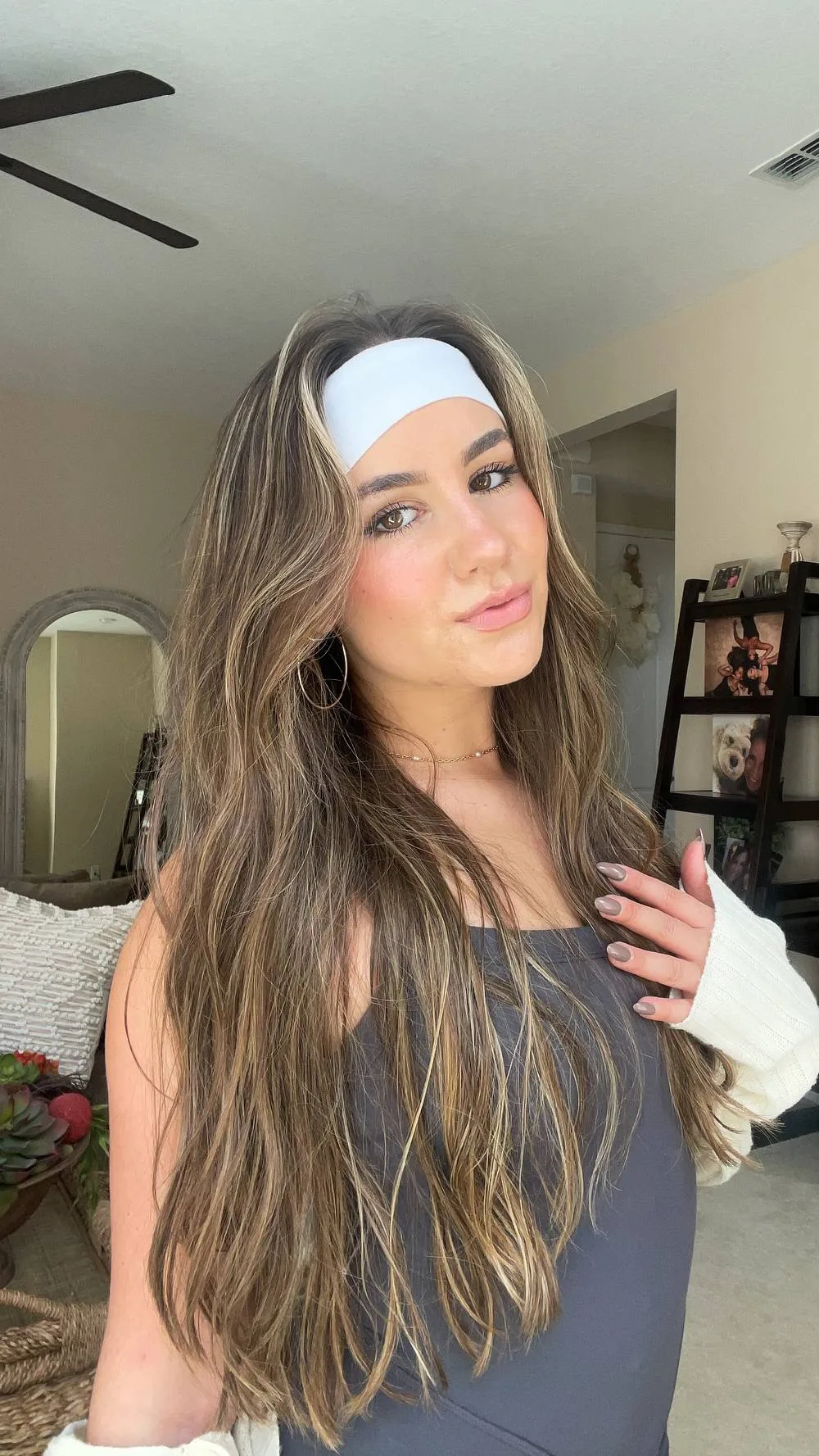 Femme avec un bandeau large satiné et de longs cheveux ondulés, de face