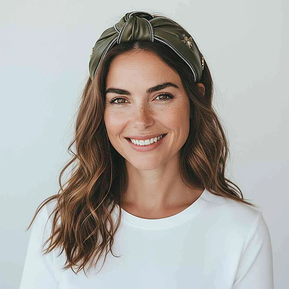 Femme avec un bandeau turban vert noué sur le dessus et cheveux ondulés, de face