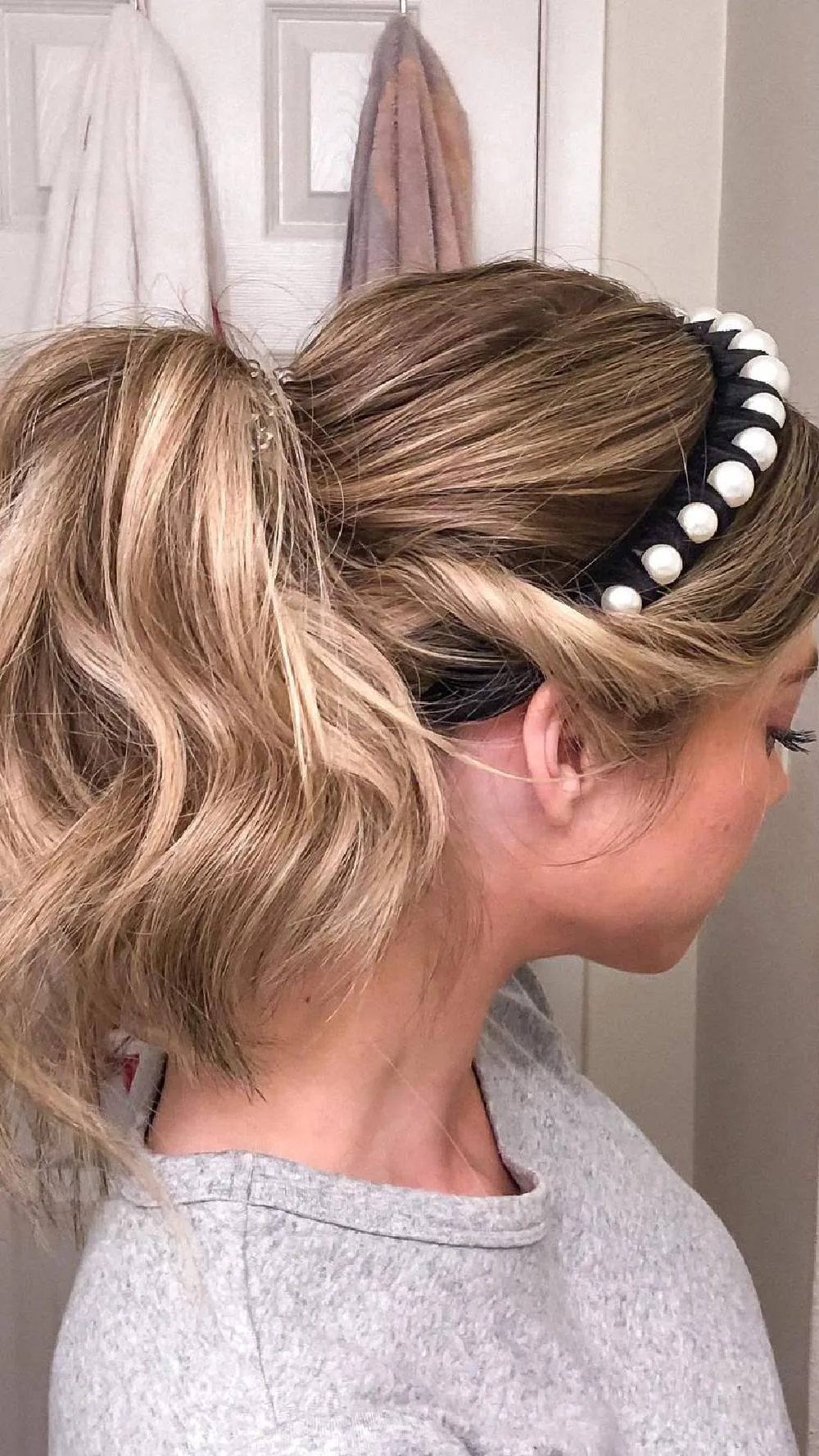Femme avec un chignon bas et un serre-tête à perles, de dos
