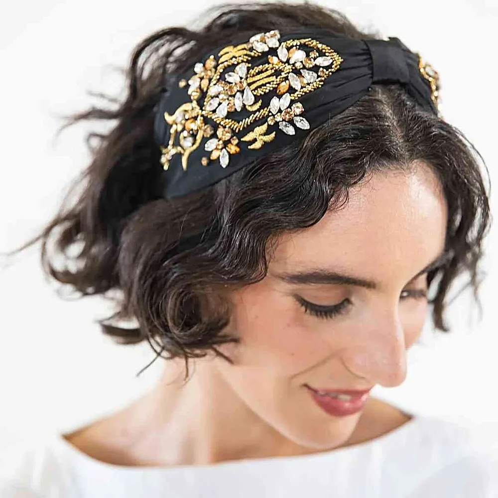 Femme avec un serre-tête orné doré statement sur un carré bouclé brun, de face