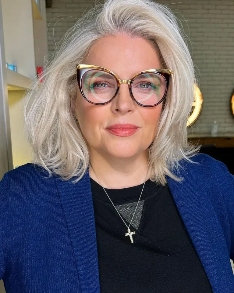 Femme de 60 ans en lob argenté effilé sur le côté avec grandes lunettes
