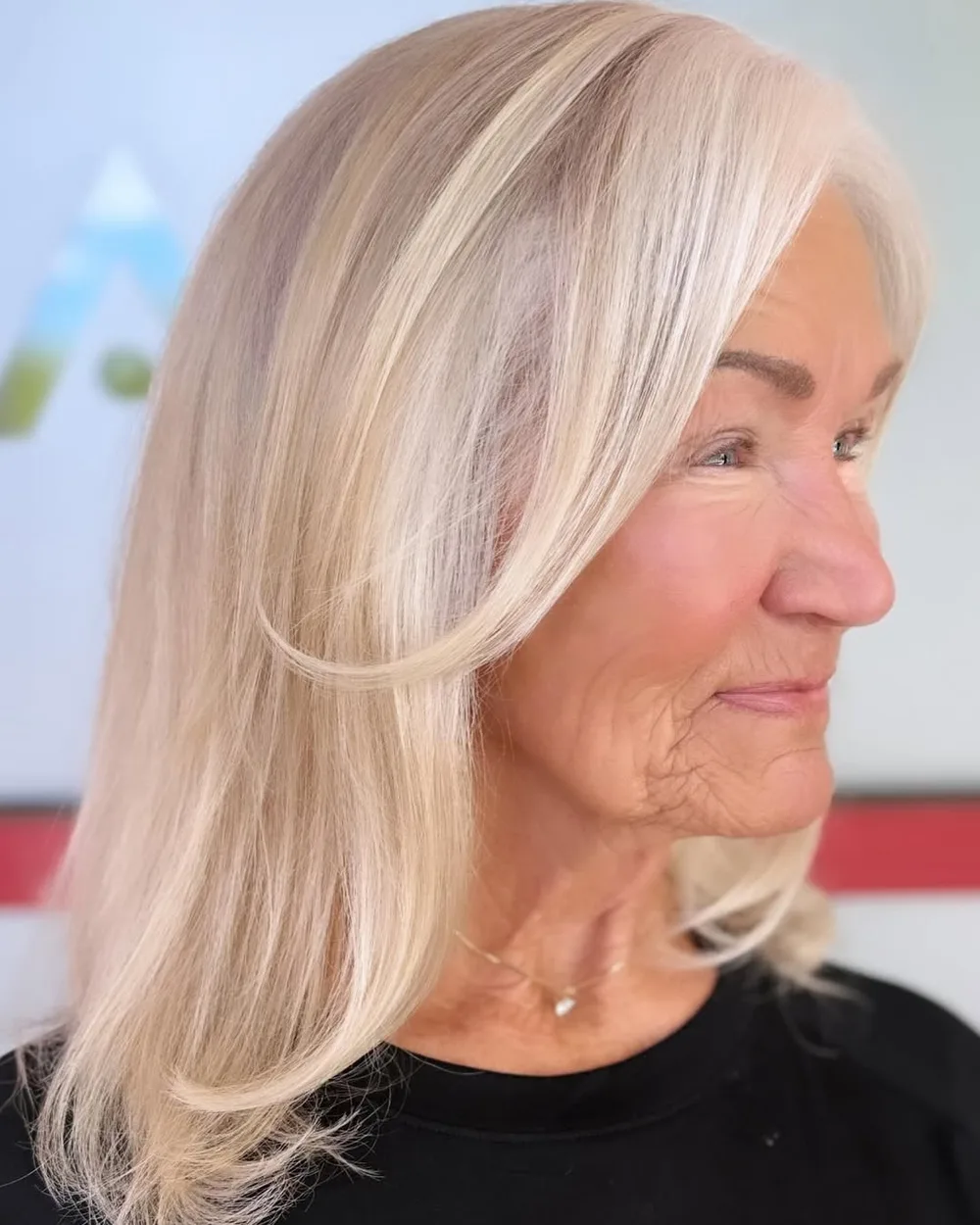 Femme de 70 ans avec carré blond et money pieces encadrant le visage, de face